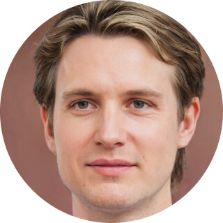 Close-up of a young man with light hair and blue eyes against a brown background.