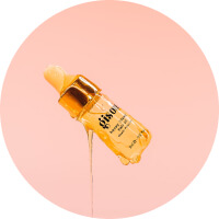 Golden serum bottle dripping on a pink background.
