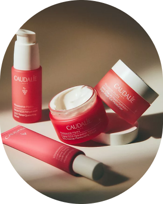 Caudalie skincare products in red packaging arranged on a surface.